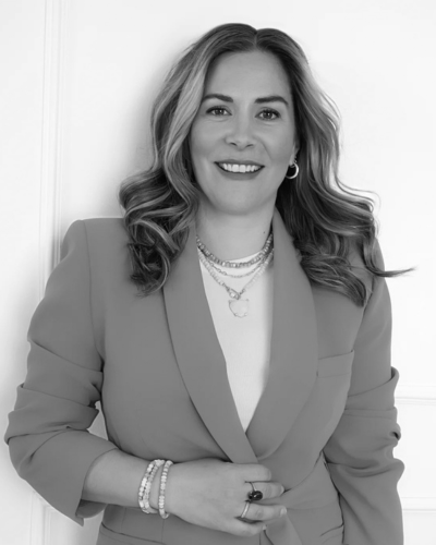 Smiling woman in a blazer and layered necklaces